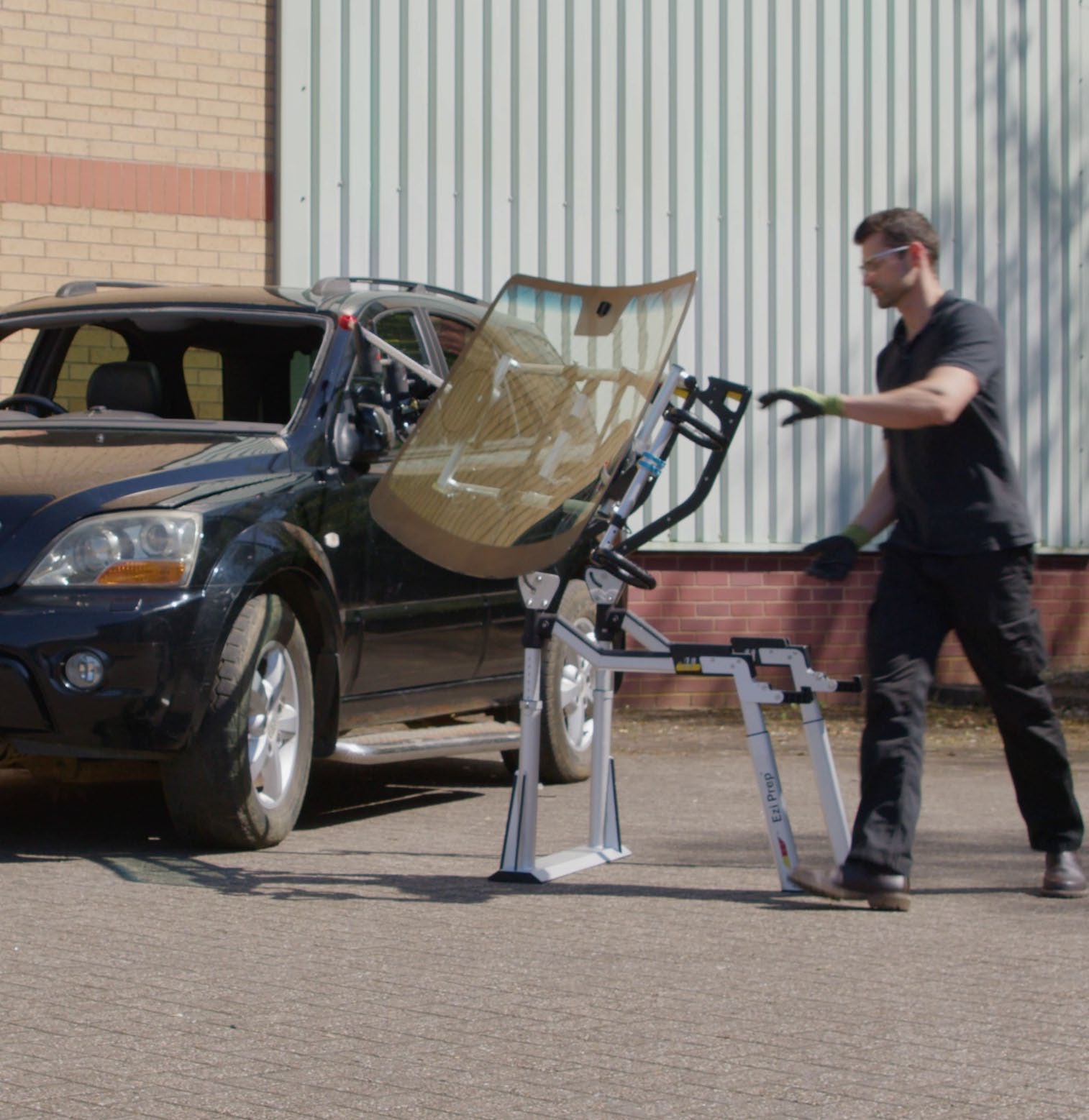A technician rotates a windscreen supported by the Ezi-Prep table and brace