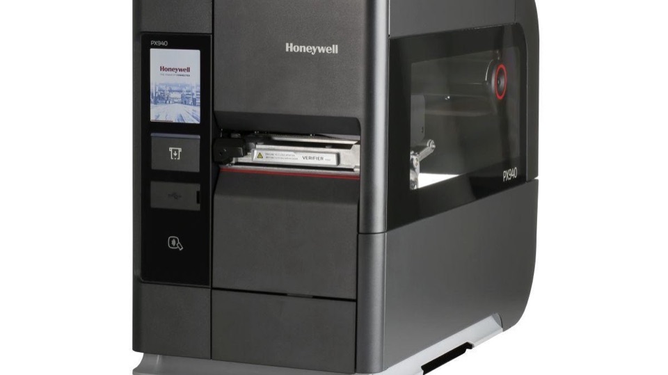 Honeywell PX940 industrial label printer with its front touchscreen and printed label